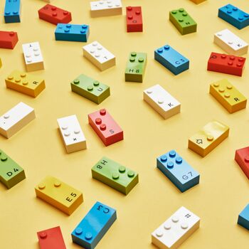 Viele farbige Lego-Bausteine mit Noppen in der Form eines Braille-Buchstabes