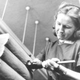 Historisches Foto: Frau mit Pinsel streicht Leim auf Buchrücken