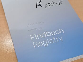 Ein Buch "Findbuch Registry" liegt auf dem Tisch.