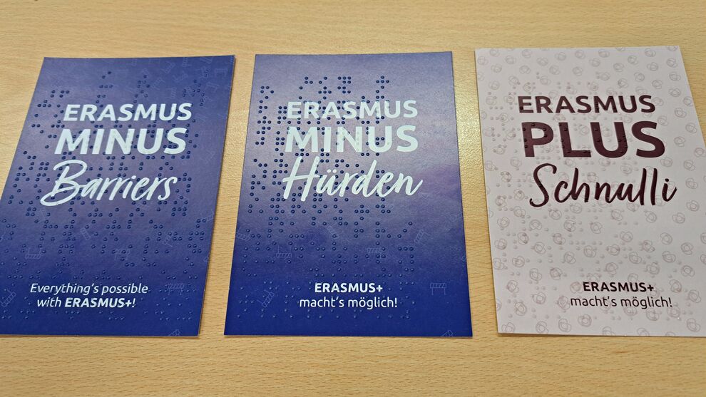 drei Karten mit weißer Schrift und Braillelack
