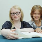 Zwei Mädchen lesen in einem Brailleschrift-Heft